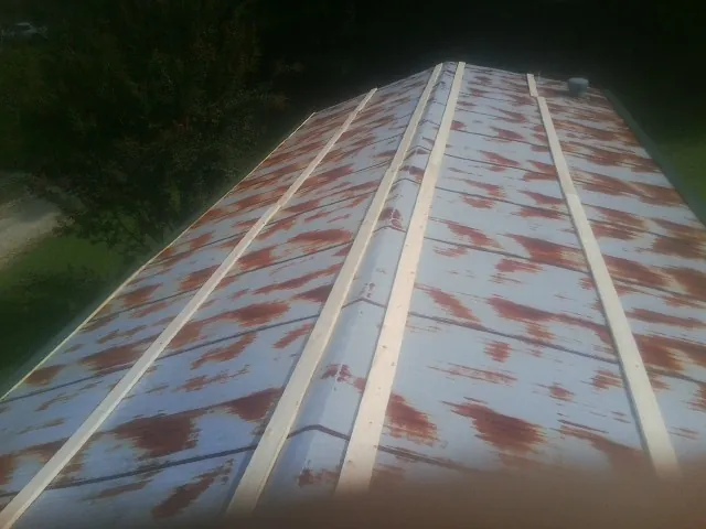 Rusted metal roof panels with new wood purlins before replacement — Storm Damage Roof Repair in Jessup by Roofing Brothers